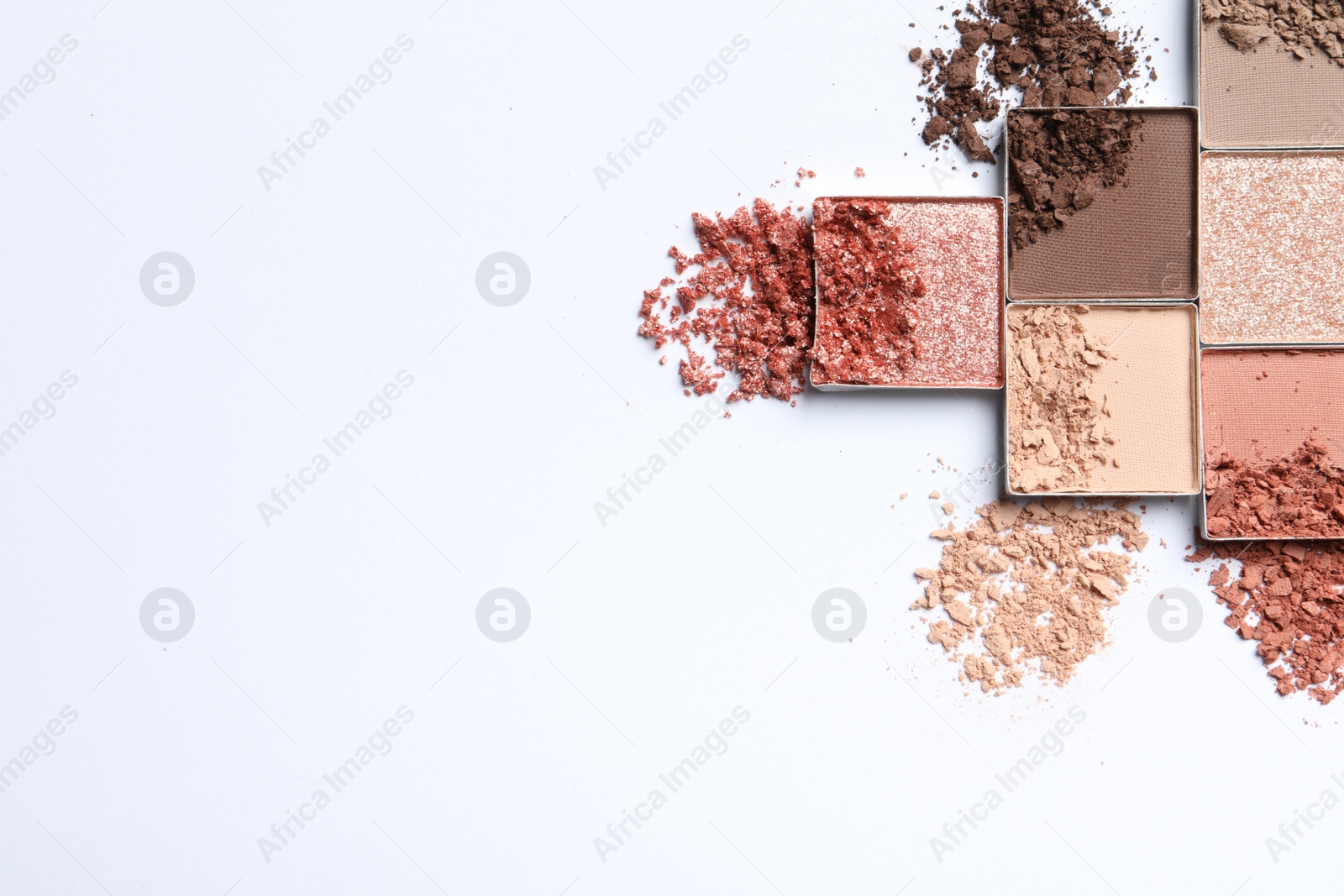 Photo of Crushed eye shadows on white background, flat lay with space for text. Professional makeup product