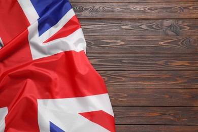 Photo of Flag of United Kingdom on dark wooden background, top view. Space for text