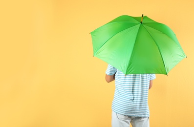 Man with green umbrella on color background