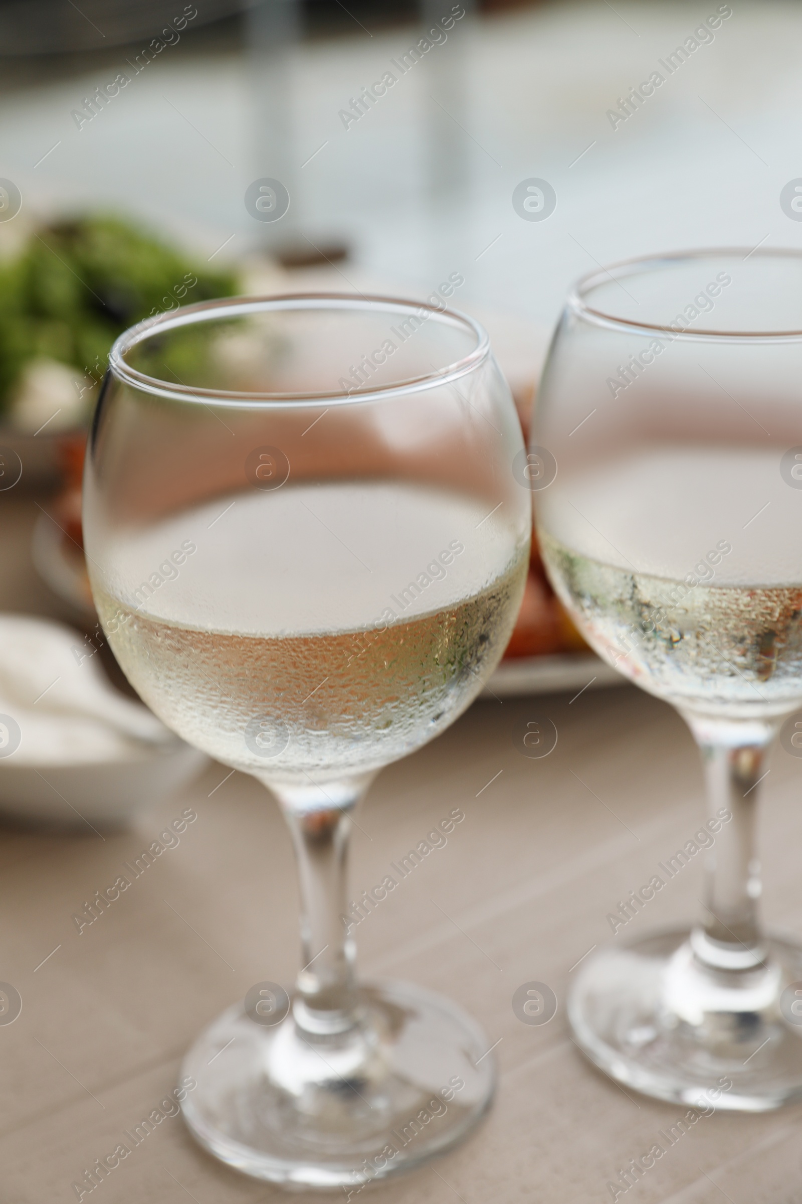 Photo of Glasses of white wine on wooden table, closeup