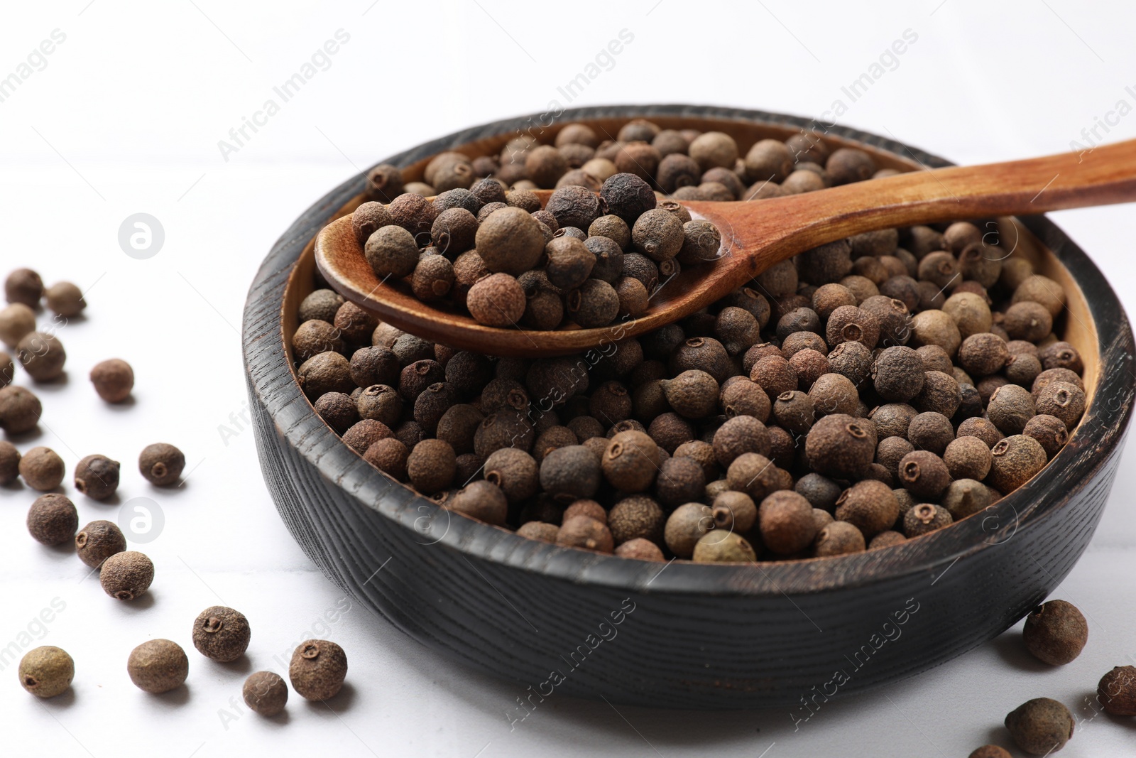 Photo of Dry allspice berries (Jamaica pepper) on white table, closeup