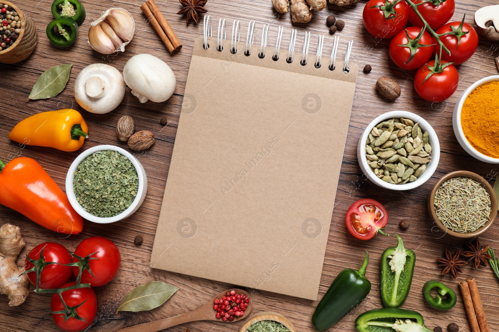 Photo of Open recipe book and different ingredients on wooden table, flat lay. Space for text