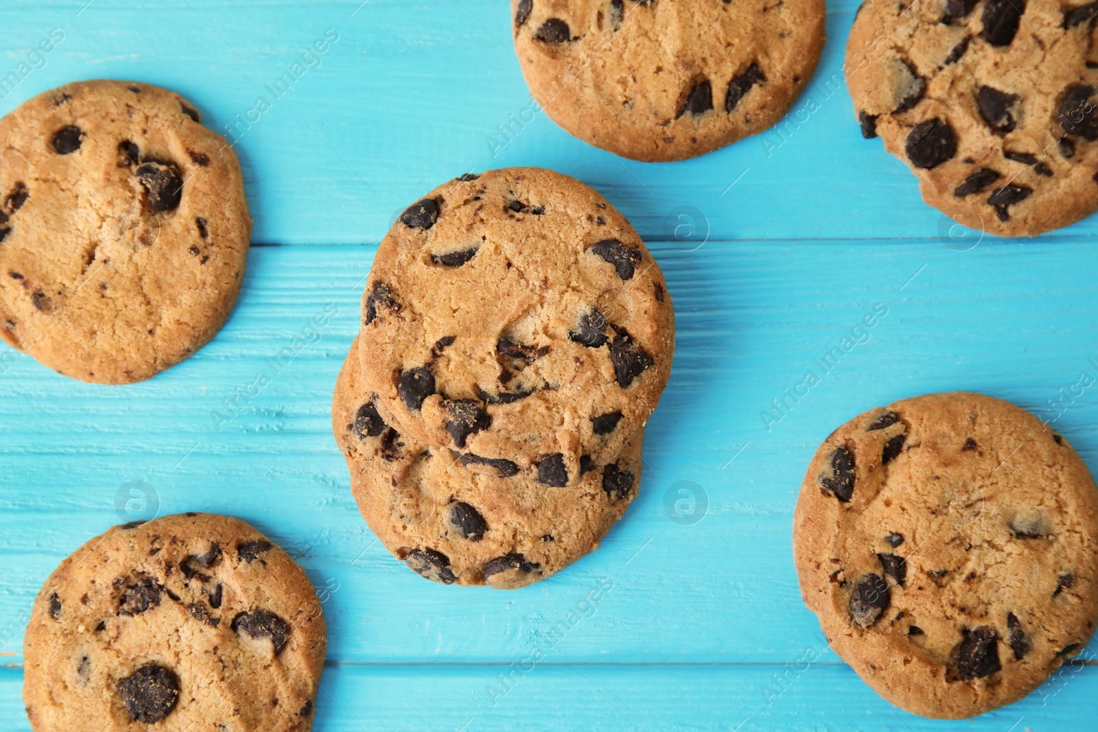 Photo of Tasty chocolate chip cookies on wooden background, top view