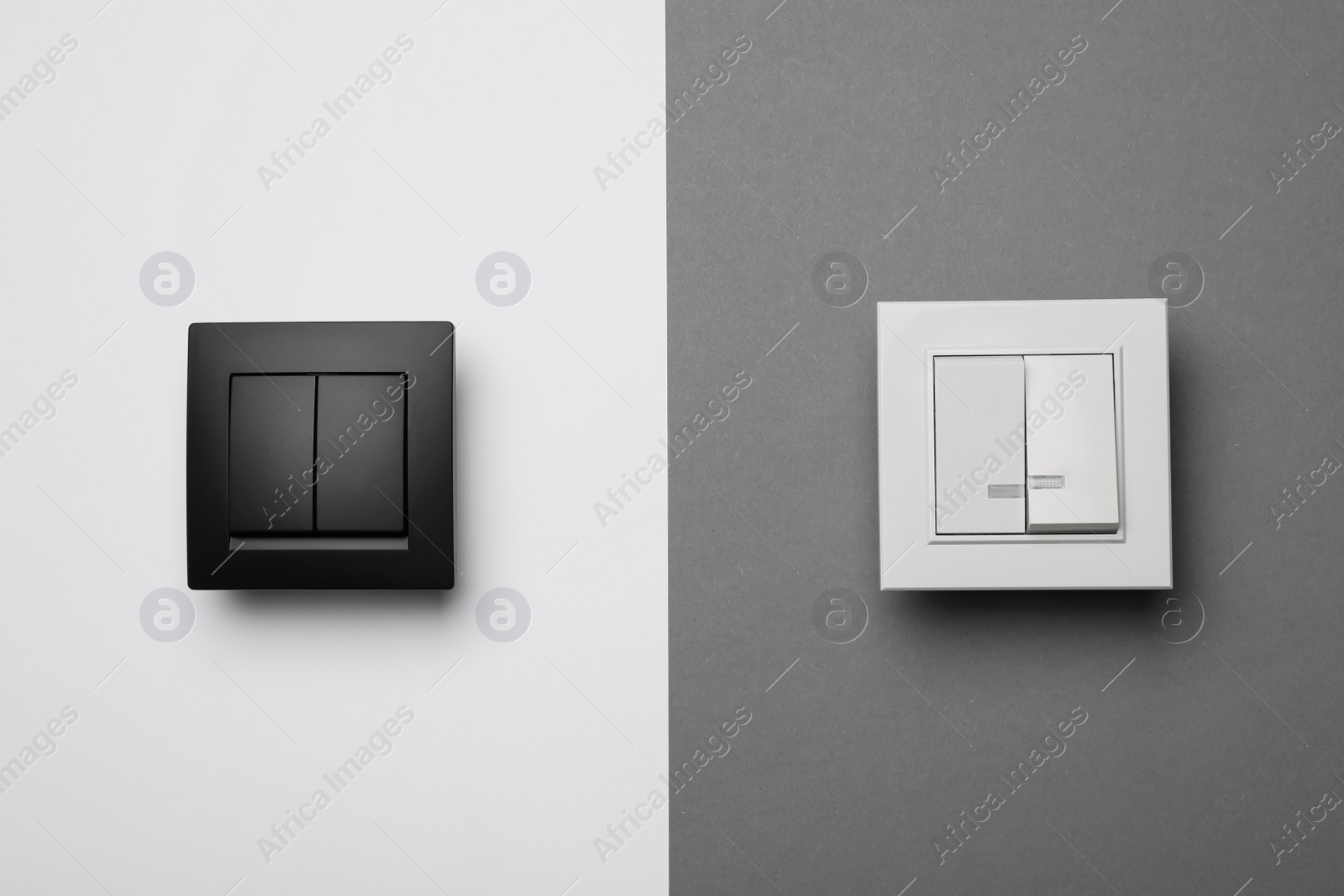 Photo of White and black light switches on color background