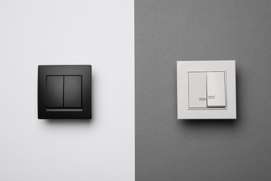 Photo of White and black light switches on color background