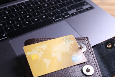 Photo of Credit card, leather wallet and laptop on table