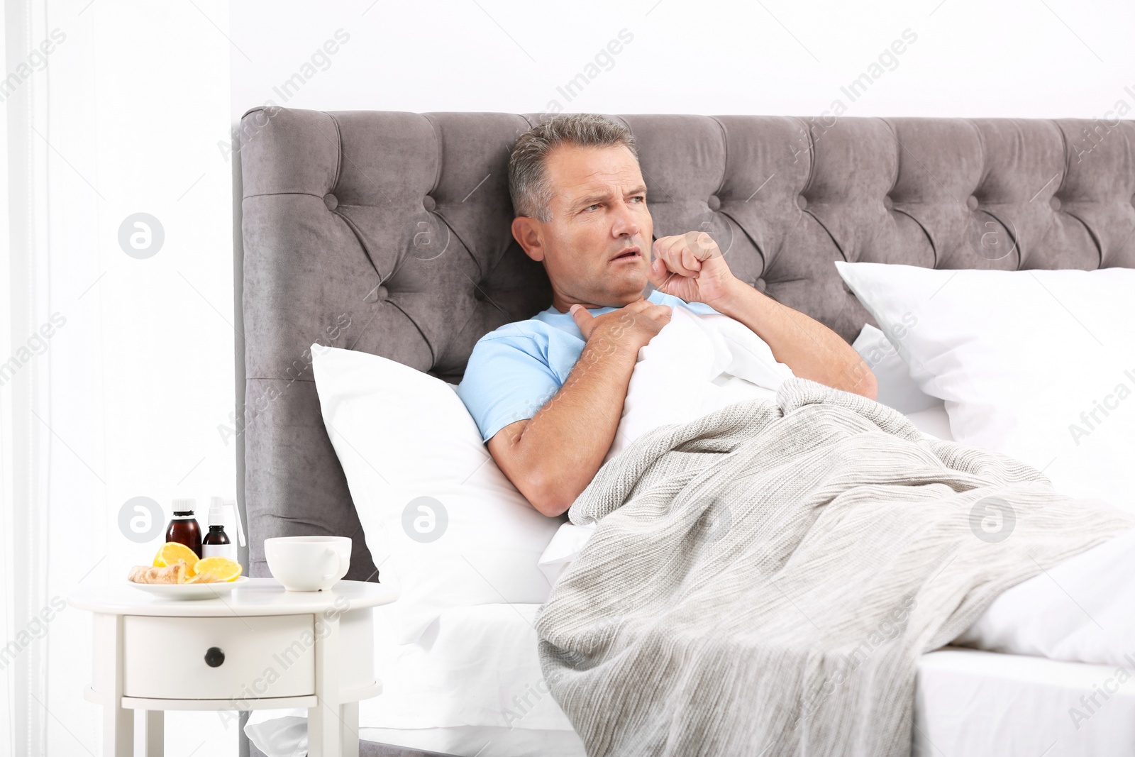 Photo of Man suffering from cough and cold in bed at home