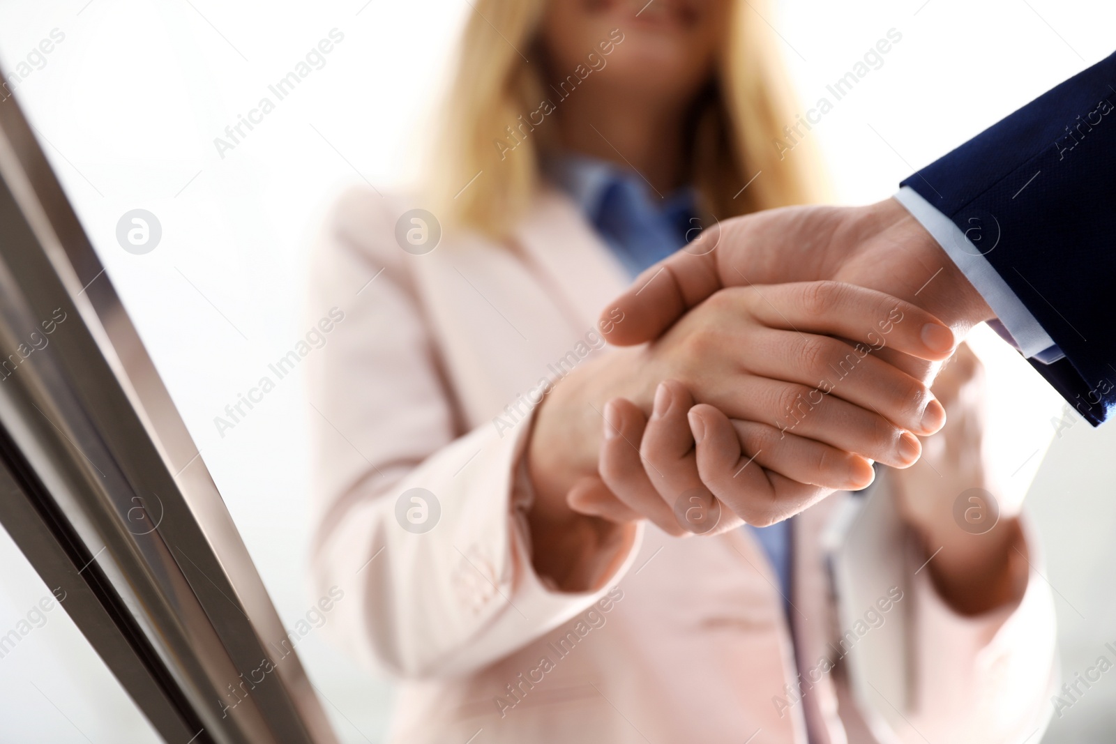 Photo of Business partners shaking hands after meeting, closeup