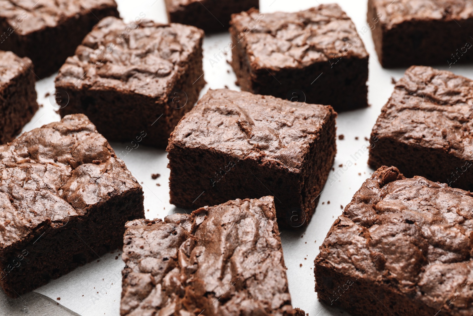 Photo of Fresh brownies on parchment paper. Delicious chocolate pie