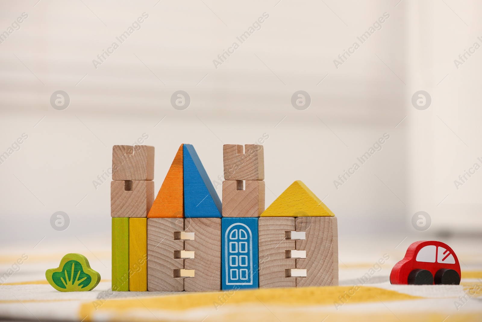 Photo of Set of wooden building blocks on floor indoors, space for text. Children's toys