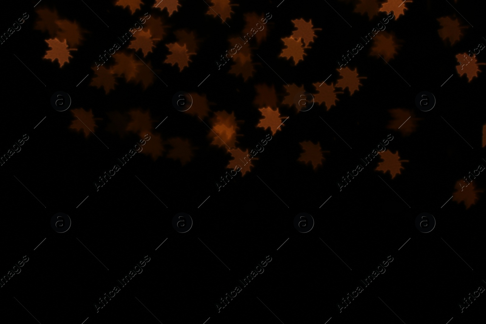 Photo of Blurred view of leaf shaped lights on dark background. Bokeh effect
