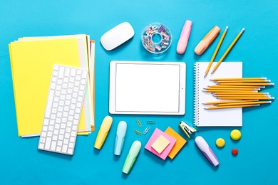 Photo of Modern tablet, keyboard and stationery on light blue background, flat lay. Space for text