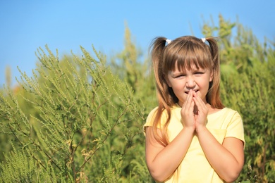 Photo of Little girl suffering from ragweed allergy outdoors