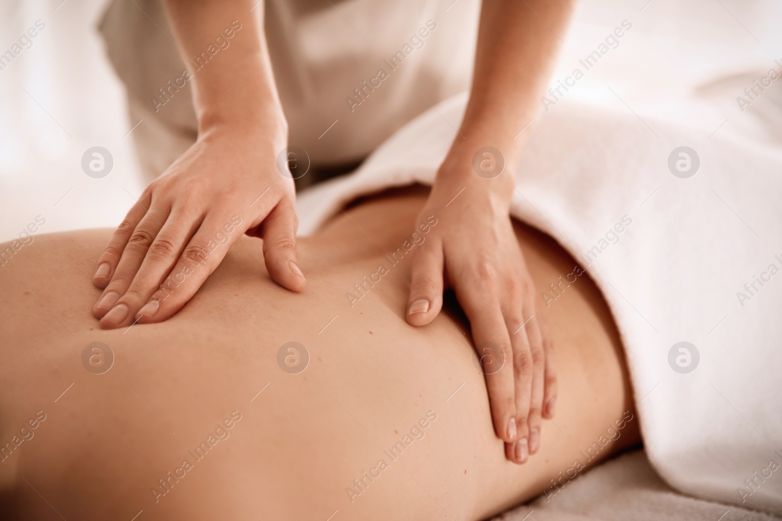 Photo of Young woman receiving back massage in spa salon, closeup