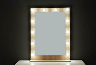 Photo of Table with mirror near color wall. Dressing room interior