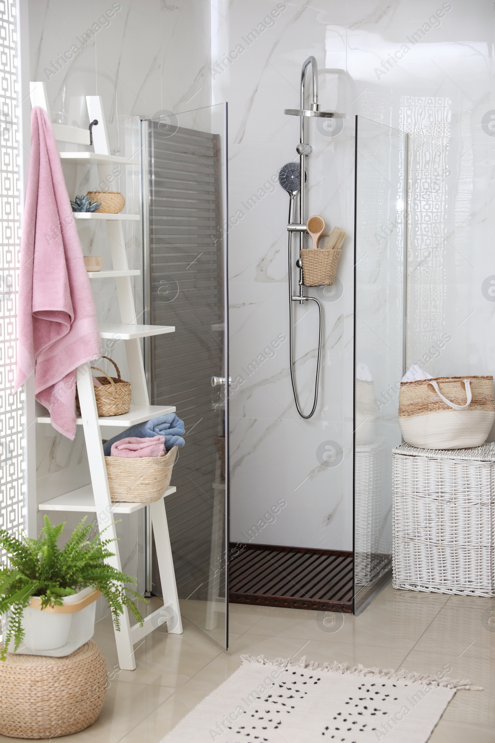 Photo of Bathroom interior with shower stall and shelving unit. Idea for design