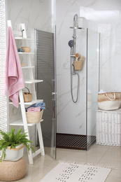 Photo of Bathroom interior with shower stall and shelving unit. Idea for design