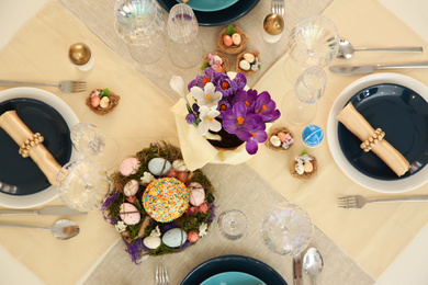 Festive Easter table setting with decorated eggs, flat lay