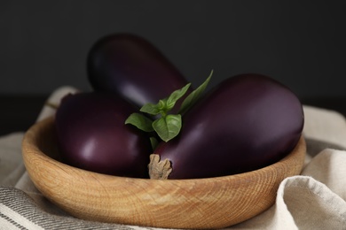 Photo of Ripe purple eggplants and basil on table, closeup