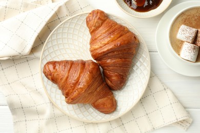 Photo of Flat lay composition with tasty croissants and cup of hot drink on white wooden table