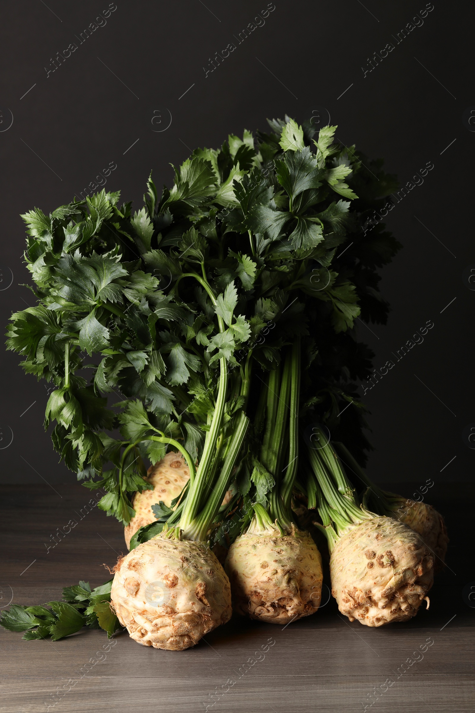 Photo of Fresh raw celery roots on wooden table