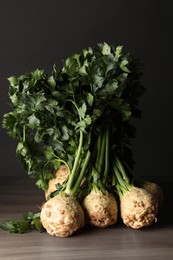 Photo of Fresh raw celery roots on wooden table