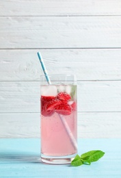 Natural lemonade with strawberries in glass on wooden table