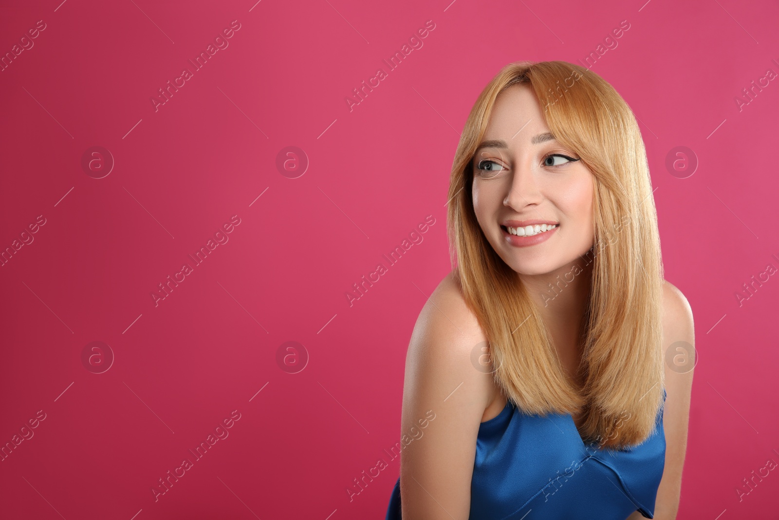 Photo of Beautiful young woman with blonde hair on pink background. Space for text