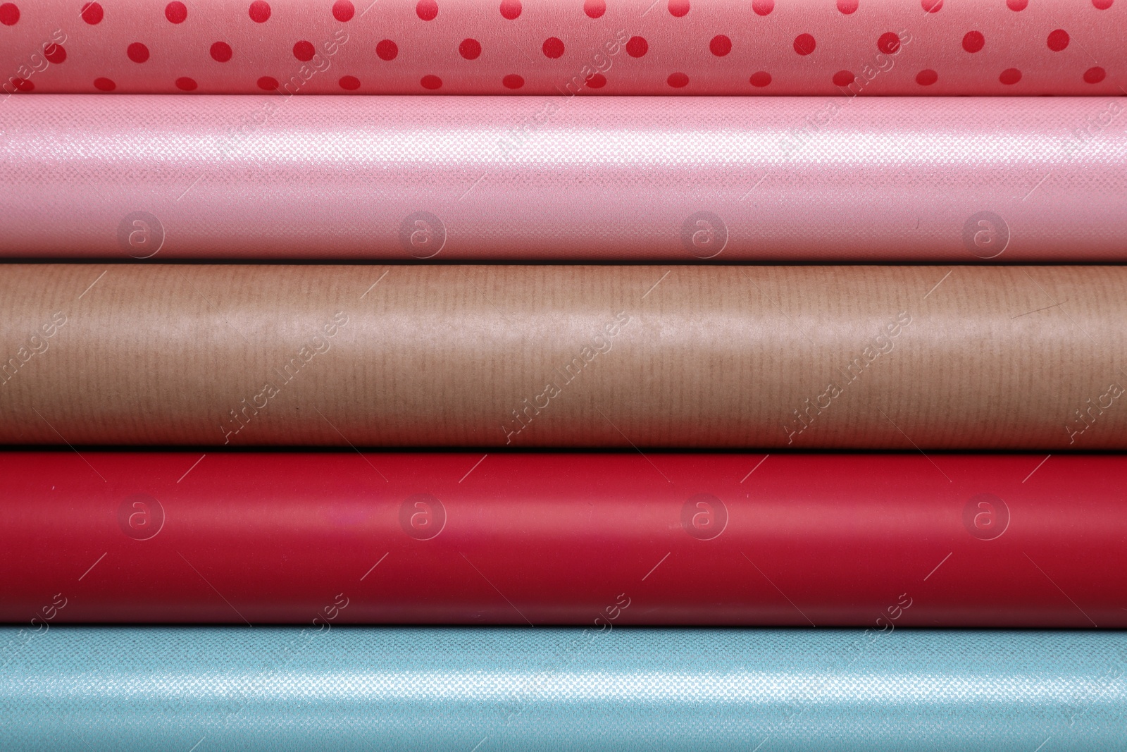 Photo of Rolls of different bright wrapping paper as background, top view