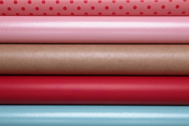 Photo of Rolls of different bright wrapping paper as background, top view