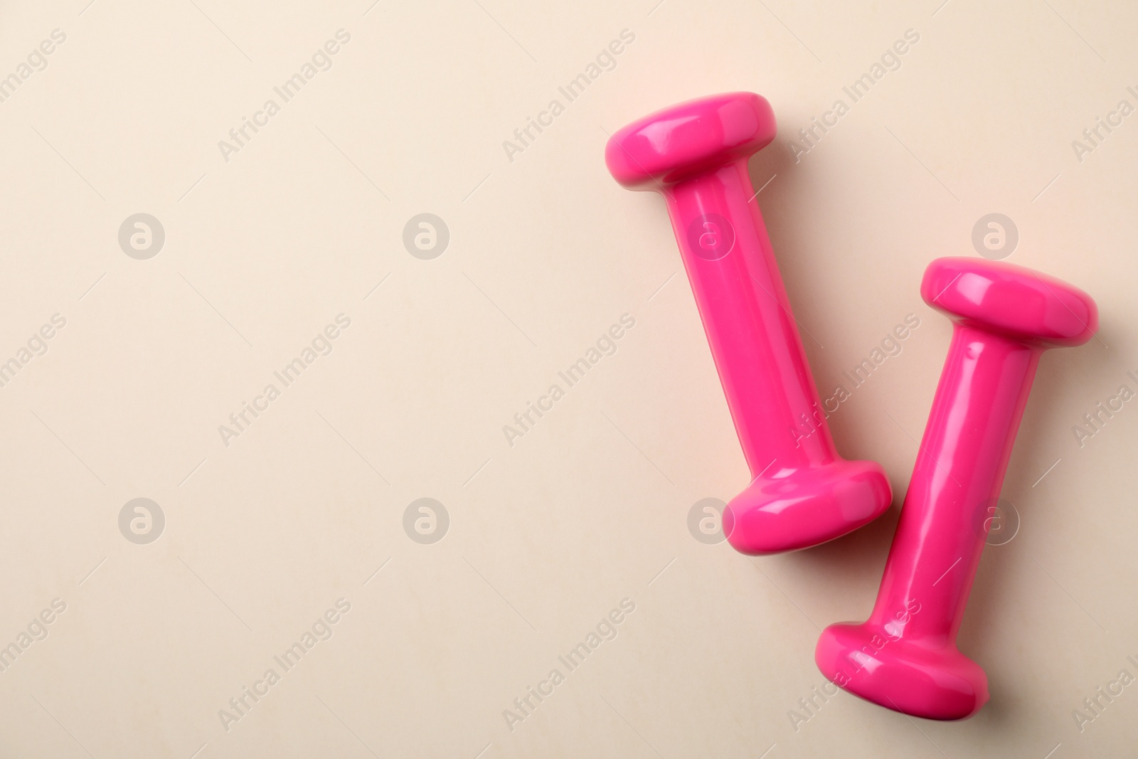 Photo of Bright dumbbells and space for text on color background, flat lay. Home fitness