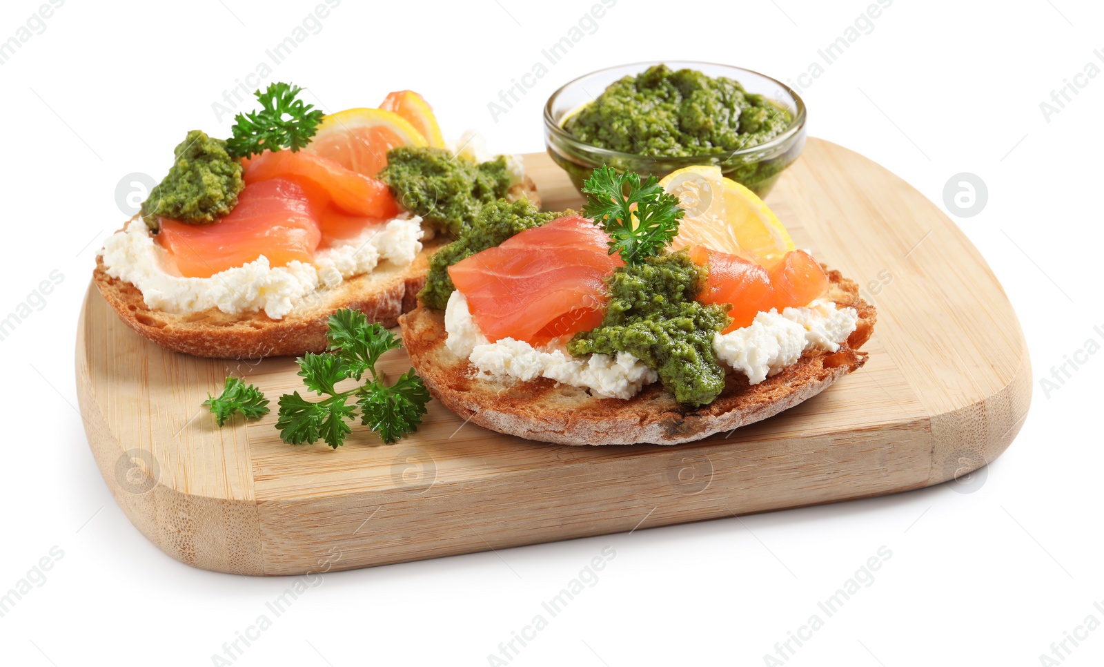 Photo of Delicious bruschettas with cream cheese, salmon and pesto sauce on white background