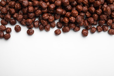 Photo of Tasty chocolate cereal balls on white background, flat lay. Space for text