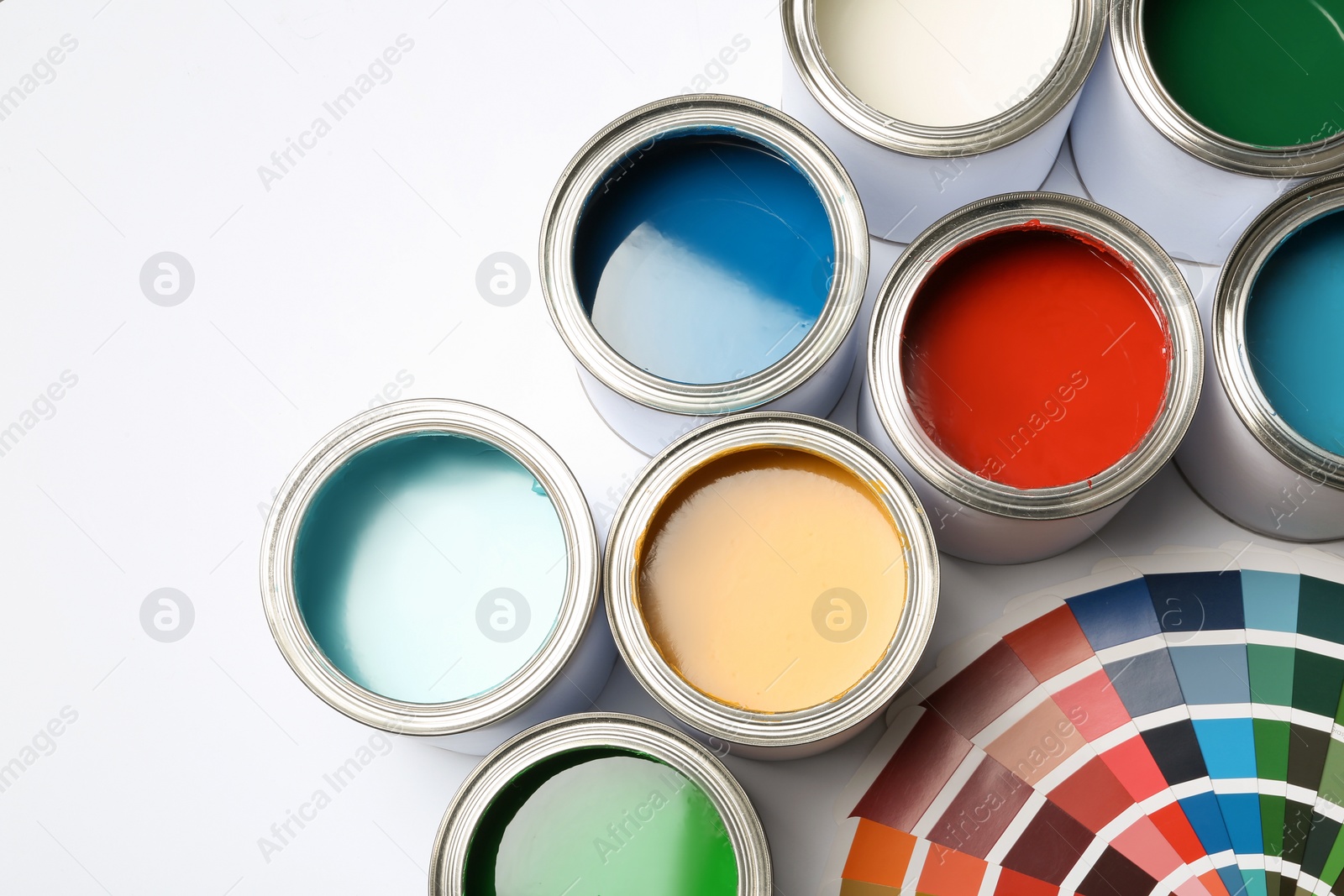 Photo of Paint cans and color palette on white background, top view