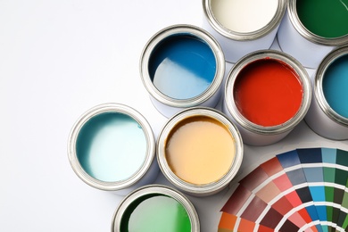 Photo of Paint cans and color palette on white background, top view