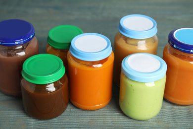 Jars with baby food on wooden table