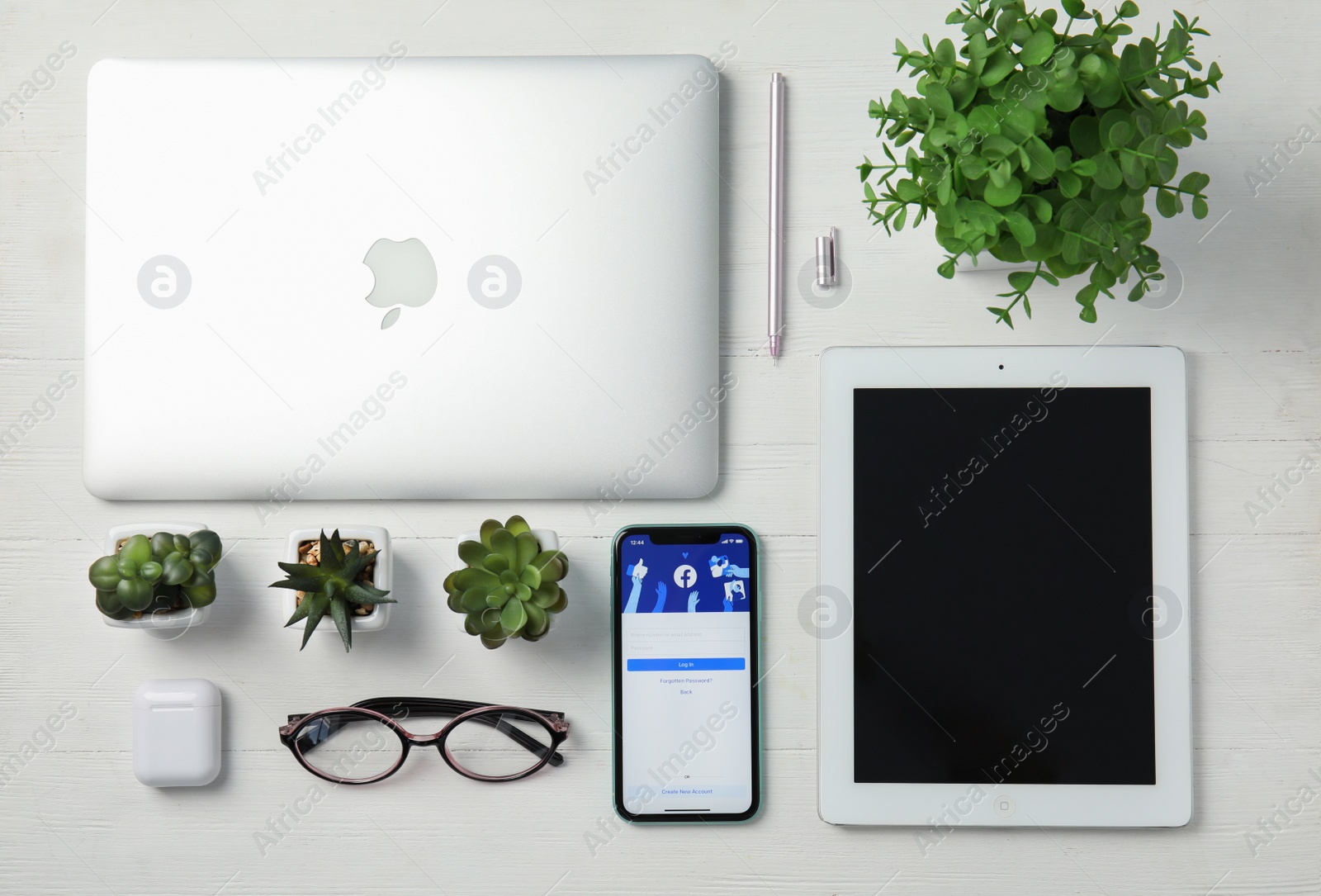 Photo of MYKOLAIV, UKRAINE - JULY 10, 2020: Flat lay composition with Iphone 11, MacBook laptop and IPad tablet on white wooden table