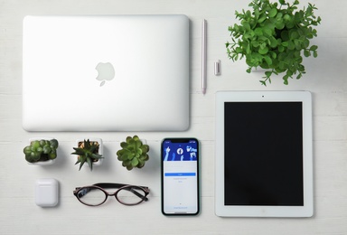 MYKOLAIV, UKRAINE - JULY 10, 2020: Flat lay composition with Iphone 11, MacBook laptop and IPad tablet on white wooden table