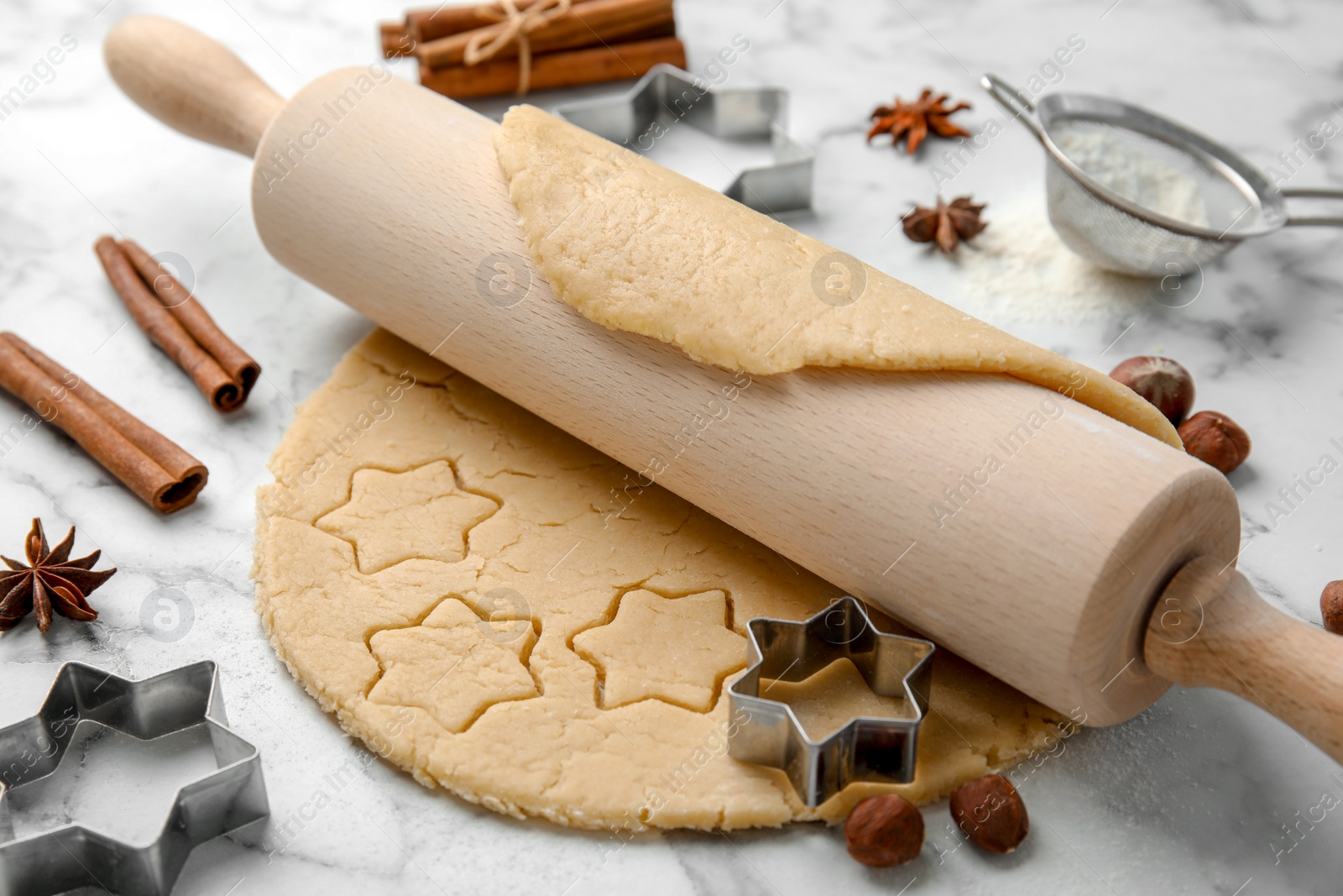 Photo of Rolling pin and raw dough for Christmas cookies on light table