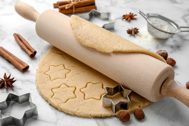 Rolling pin and raw dough for Christmas cookies on light table