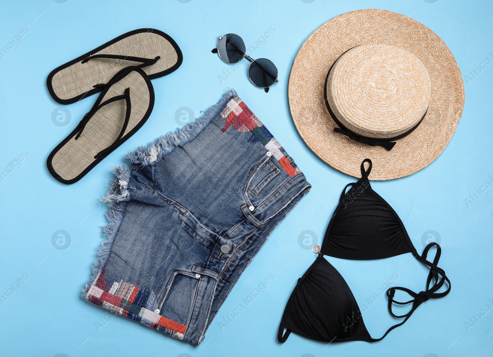 Photo of Flat lay composition with stylish beach accessories on light blue background