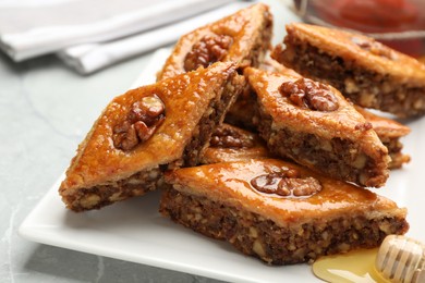 Delicious baklava with walnuts on light grey marble table, closeup