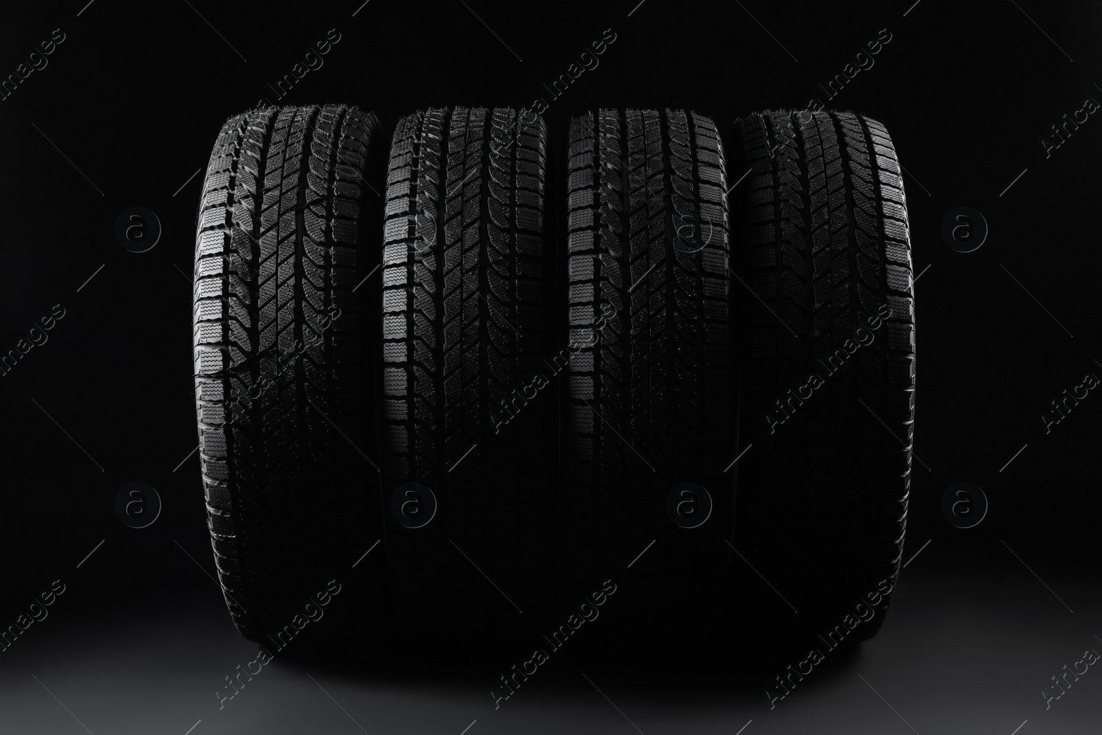 Photo of Set of winter tires on black background