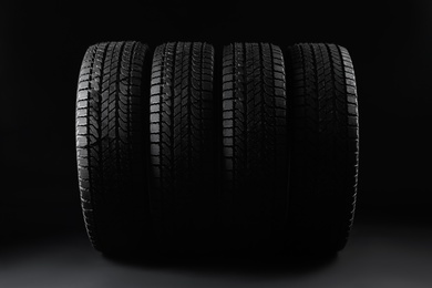 Photo of Set of winter tires on black background