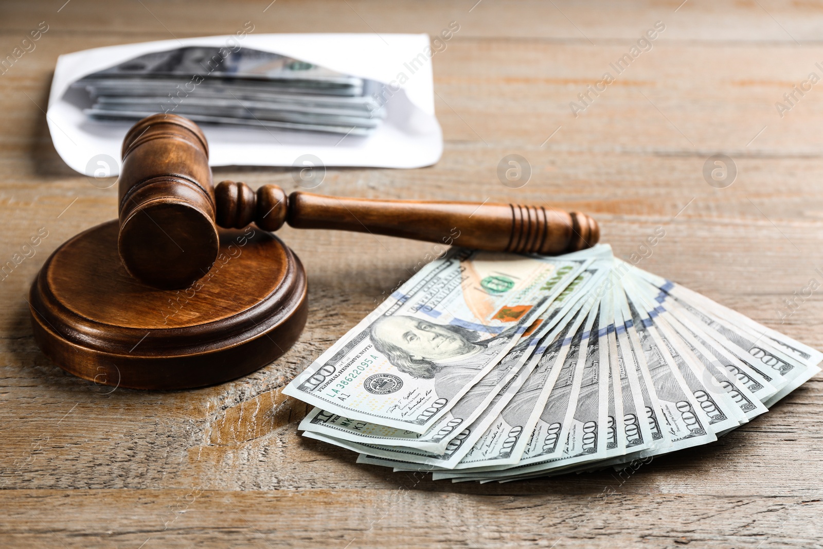 Photo of Dollar bills and gavel on wooden table. Bribe concept