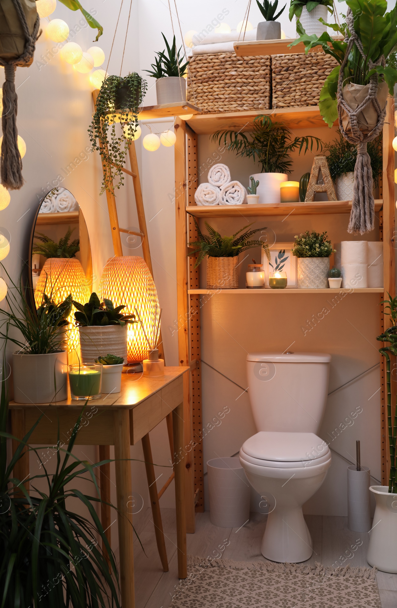 Photo of Stylish bathroom interior with toilet bowl and green plants