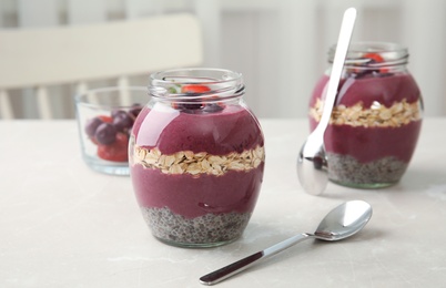 Jars of tasty acai smoothie on light table