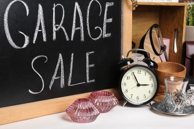 Photo of Blackboard with sign Garage Sale and many different stuff on white background