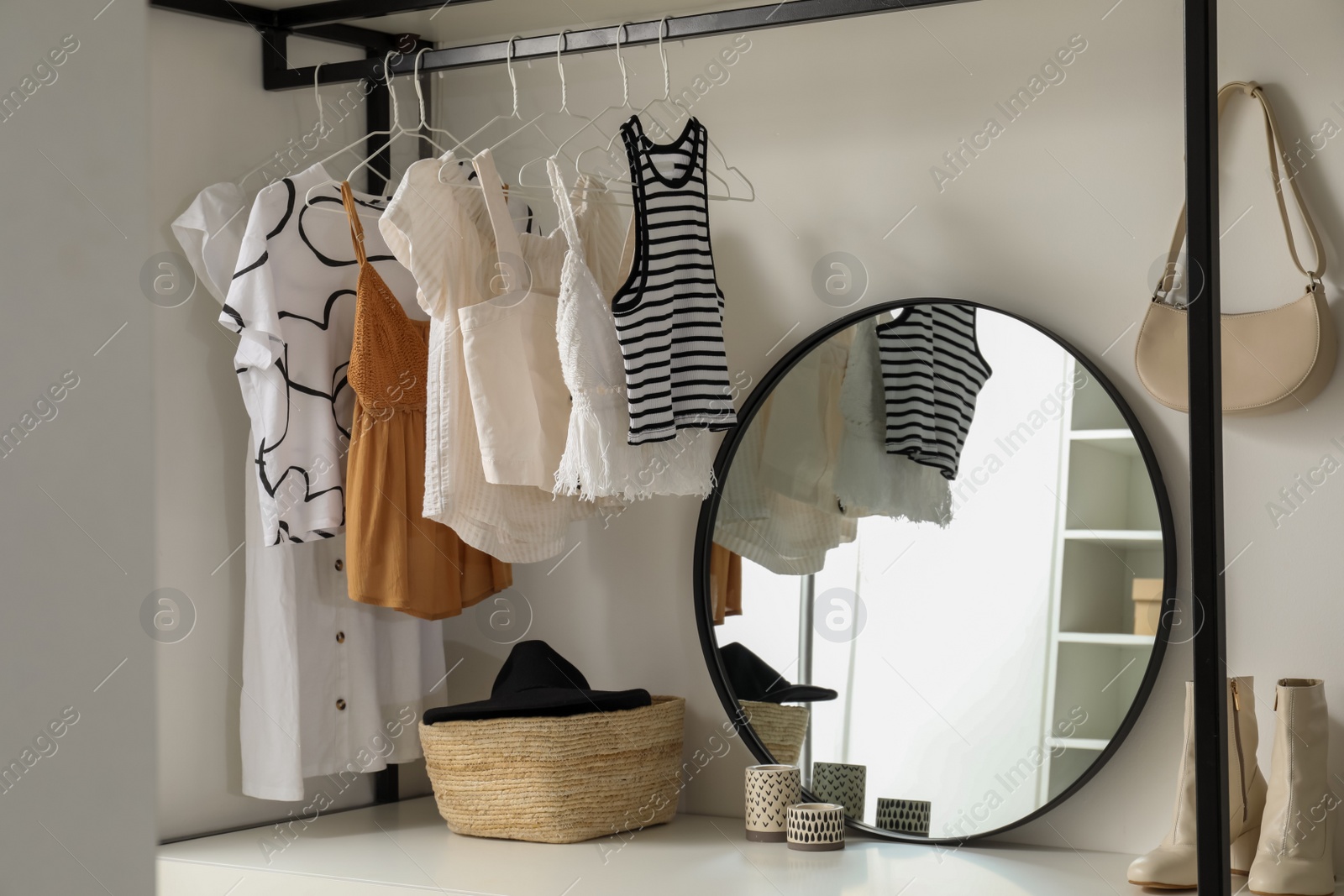 Photo of Storage rack with stylish women's clothes and accessories indoors