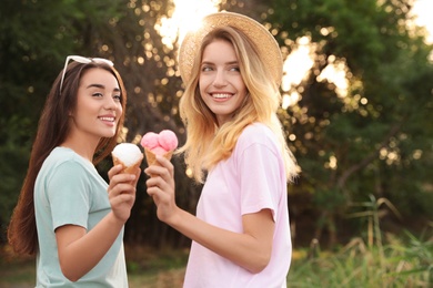 Photo of Young women with ice cream spending time together outdoors